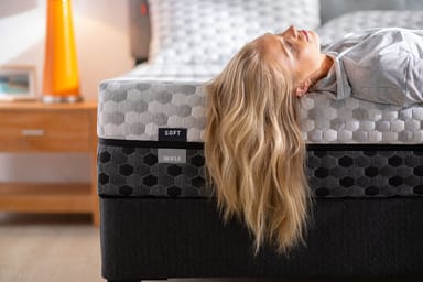 Woman laying on edge of memory foam mattress