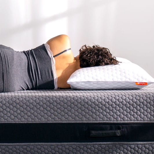 Woman laying down on hybrid mattress