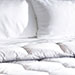 Close up of the white comforter and sheets
