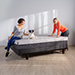 Two women and a dog sitting on a mattress