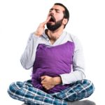 Pajamas Affect Sleep: Man in pajamas yawning
